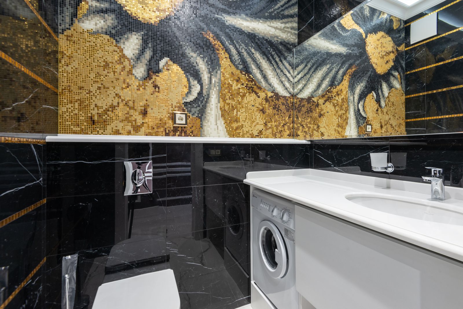 Bathroom with gold mosaic tile, black marble and a white lacquered vanity