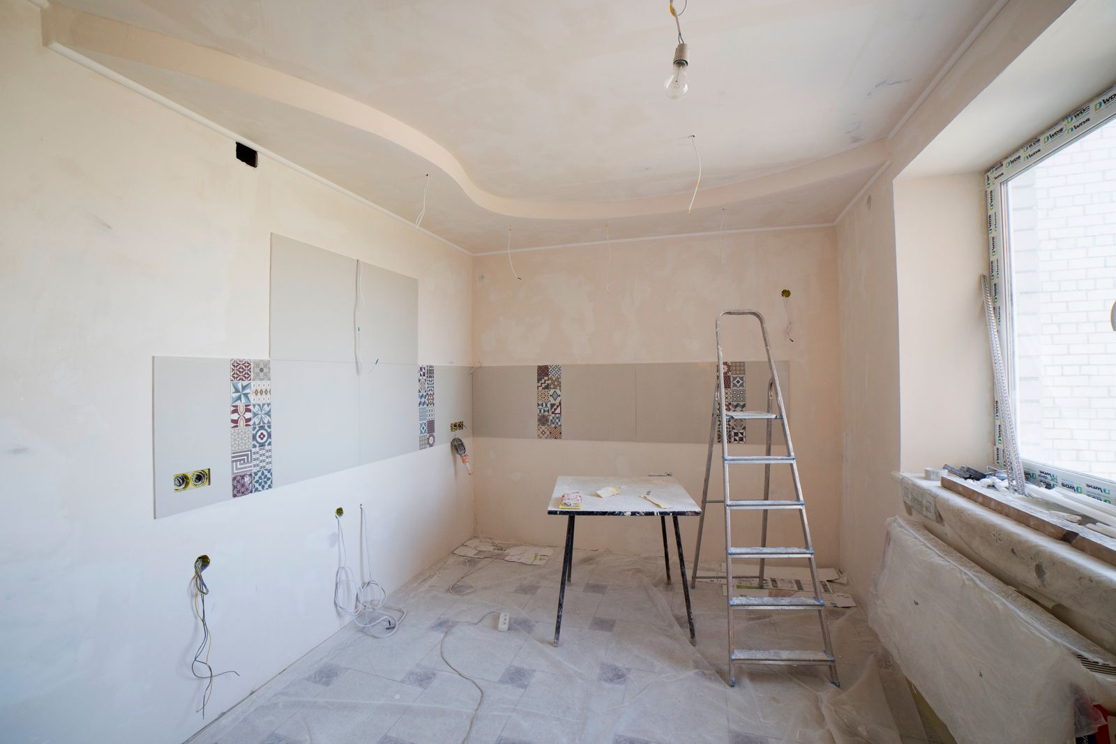 Room under construction with a curved plaster ceiling and tile going up