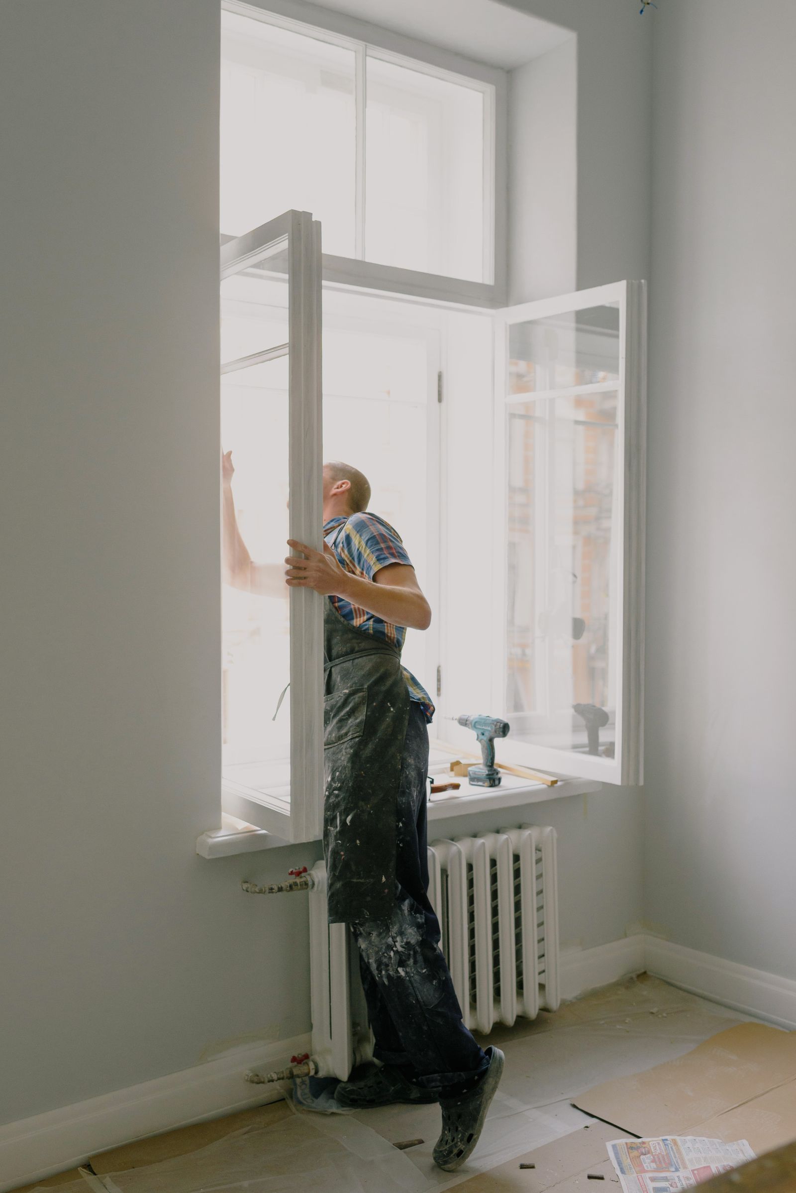 Carpenter fitting a new window sash in a home