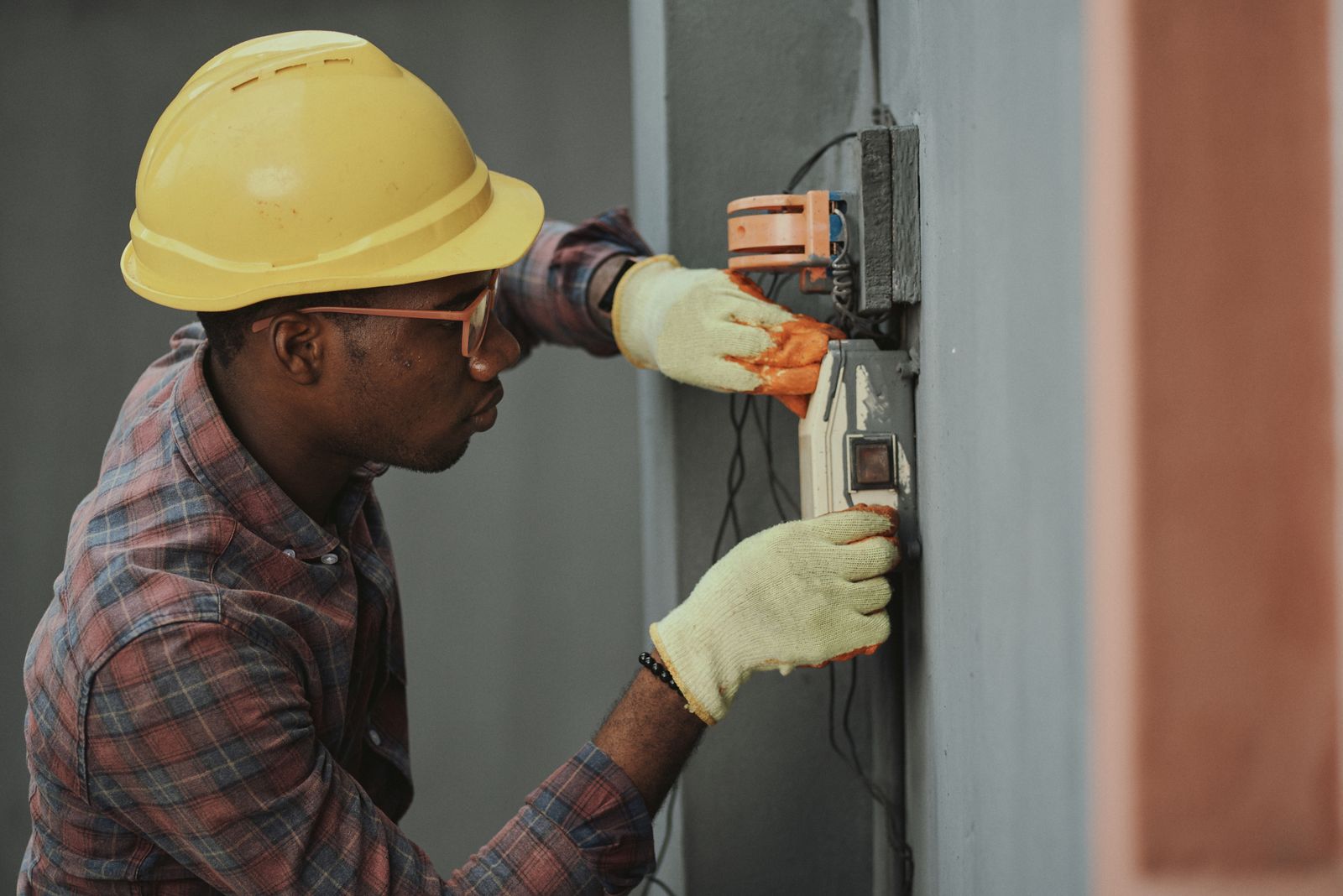 Worker installing an electrical box in a wall during the remodel